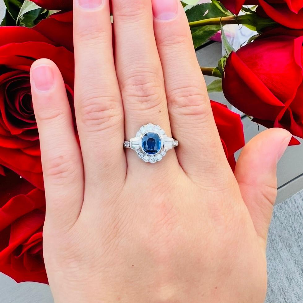 Ispirazione Art Deco al massimo! Questo delizioso anello in platino ha al centro uno zaffiro di forma ovale del peso di 1,27 carati, circondato da diamanti rotondi a taglio brillante e baguette, per un peso totale di 0,66 carati. L'anello pesa 2,8