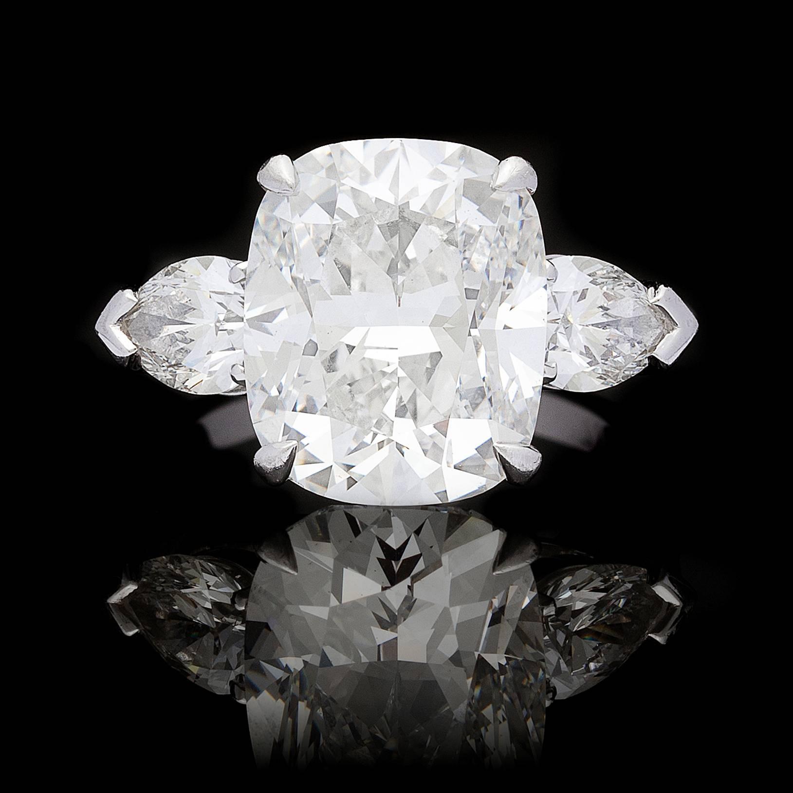 This spectacular Graff 3-stone diamond platinum ring features a center 7.14 carat cushion-cut diamond flanked by pear-shaped diamonds on each side which total 1.40 carats. Stamped on the inside of the ring are the world renowned maker’s name and the