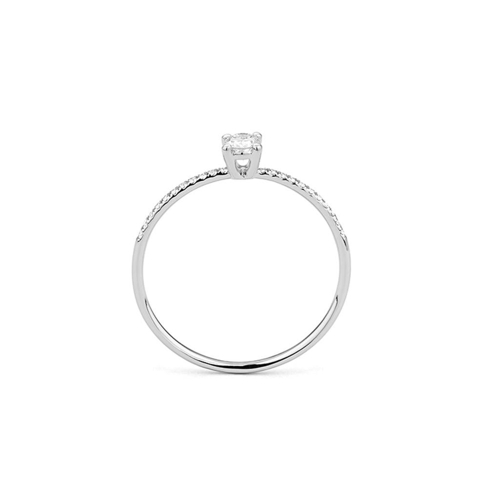Raffinée et intemporelle, cette bague en or blanc 18 ct est ornée d'un diamant de taille ovale serti en son centre, complété par un fin anneau serti de diamants qui rehausse son gracieux éclat. La silhouette allongée de la pierre ovale ajoute une