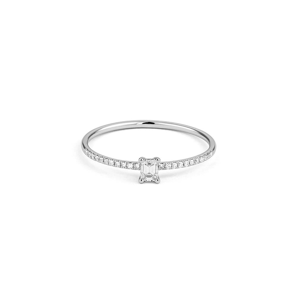 Dieser Ring aus 18 Karat Weißgold zeichnet sich durch einen eleganten Diamanten im Smaragdschliff aus, der in ein feines diamantbesetztes Band eingefasst ist. Die klaren Linien des Steins im Stufenschliff verleihen ihm eine architektonische Eleganz,