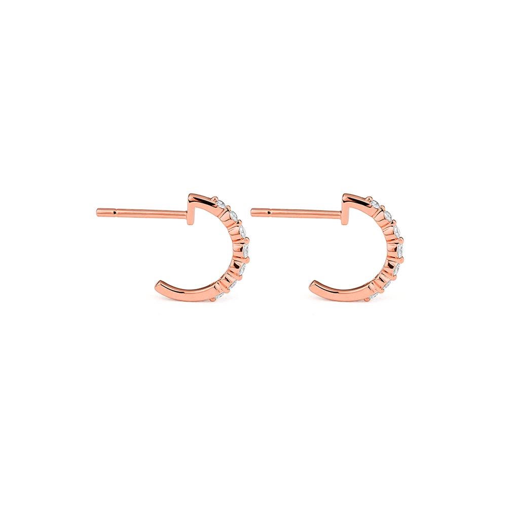 Gracieuses et étincelantes, ces boucles d'oreilles en or rose 18ct présentent un arc raffiné de 14 diamants ronds de taille brillant. Avec une courbe douce qui épouse délicatement le lobe, ils offrent une alternative moderne aux cerceaux