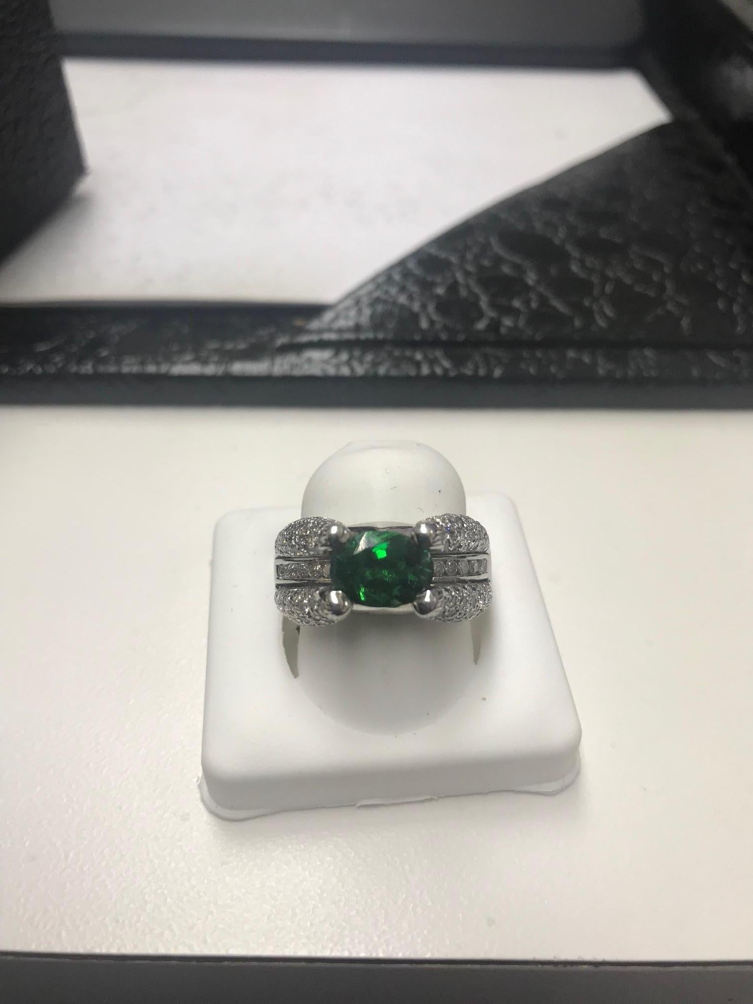 Verleihen Sie Ihrer Schmucksammlung einen Hauch von Luxus mit diesem exquisiten Tsavorit-Ring aus poliertem 14 Karat Weißgold mit 2,16 Karat Mittelstein und 1,42 Karat Diamanten rundherum. Mit einem schillernden natürlichen Tsavorit-Granat, der für