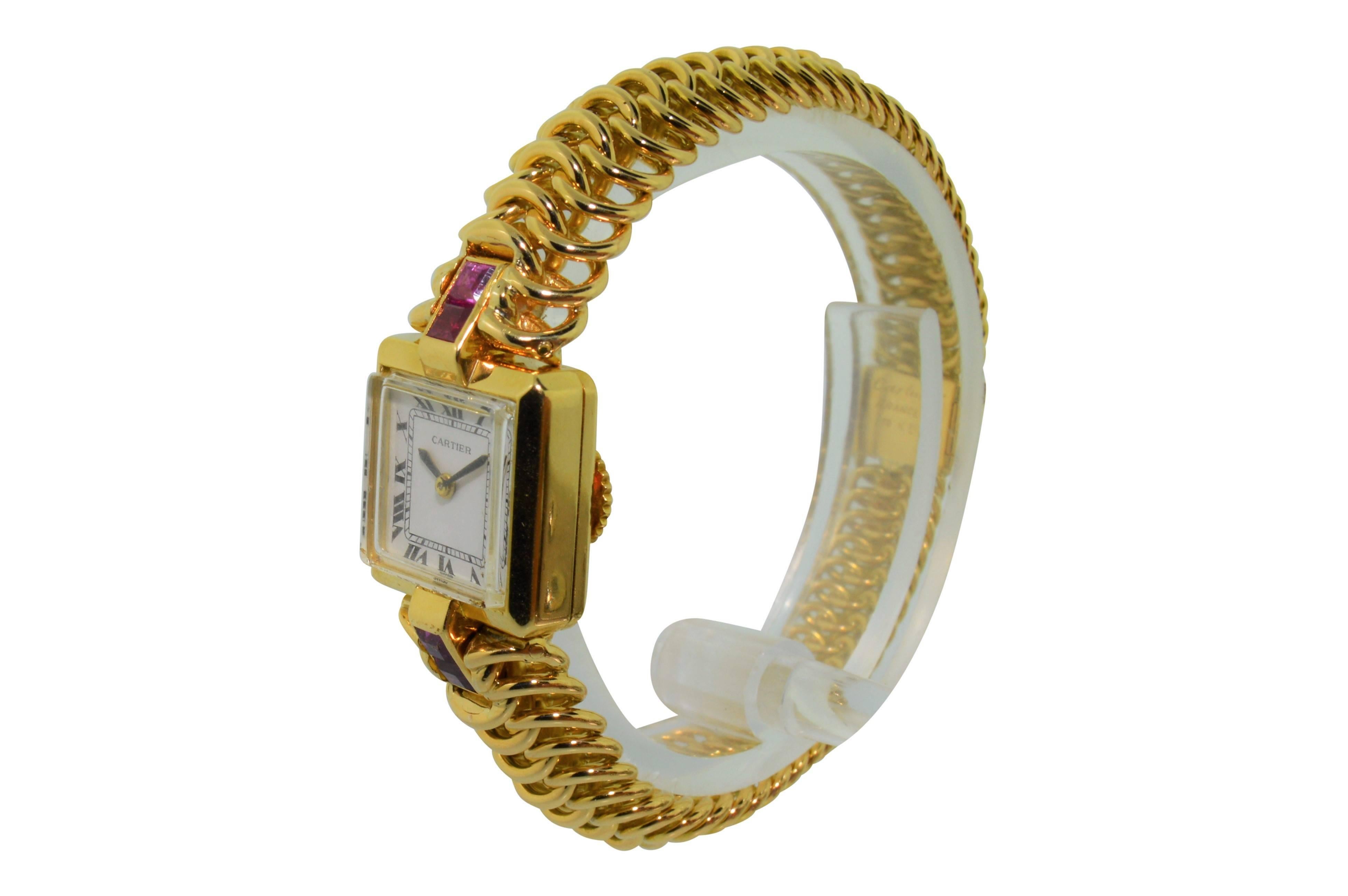 FACTORY / HOUSE: Cartier by Le Coultre / Ruby Set Bracelet Dress Watch
STYLE / REFERENCE: Art Deco
METAL / MATERIAL: 18Kt. Yellow Gold
CIRCA: 1950's
DIMENSIONS: 16mm  X 16mm
MOVEMENT / CALIBER: Back Winding / 17 Jewels
DIAL / HANDS: Roman with Leaf