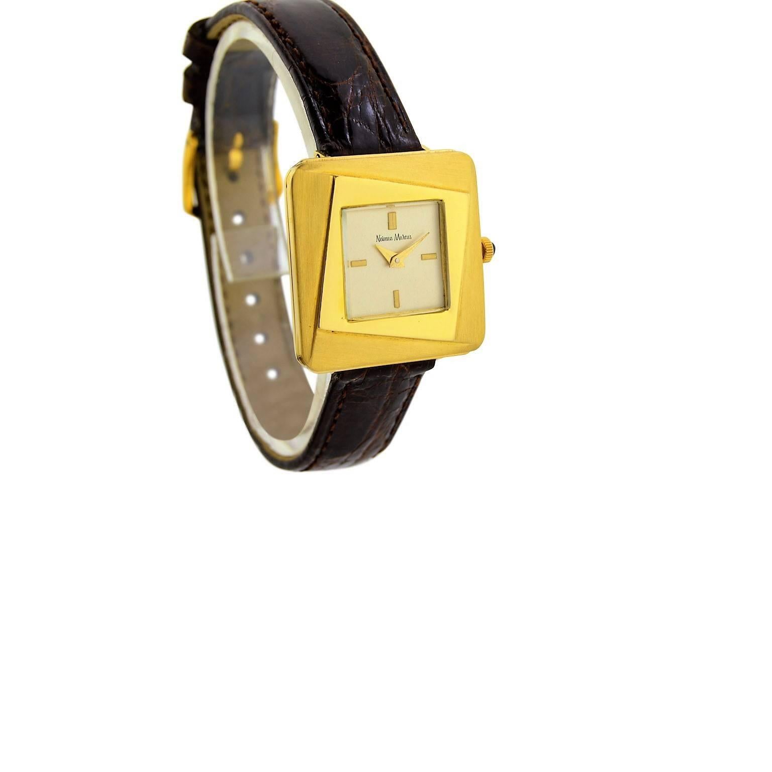 FACTORY / HOUSE: Neiman Marcus
STYLE / REFERENCE: Square / Moderne Mid Century
METAL / MATERIAL: 18Kt. Yellow Gold
DIMENSIONS:  28mm X 26mm
CIRCA: 1960's
MOVEMENT / CALIBER: Manual Winding /  17 Jewels 
DIAL / HANDS: Silver w/ Batons / Dauphine
