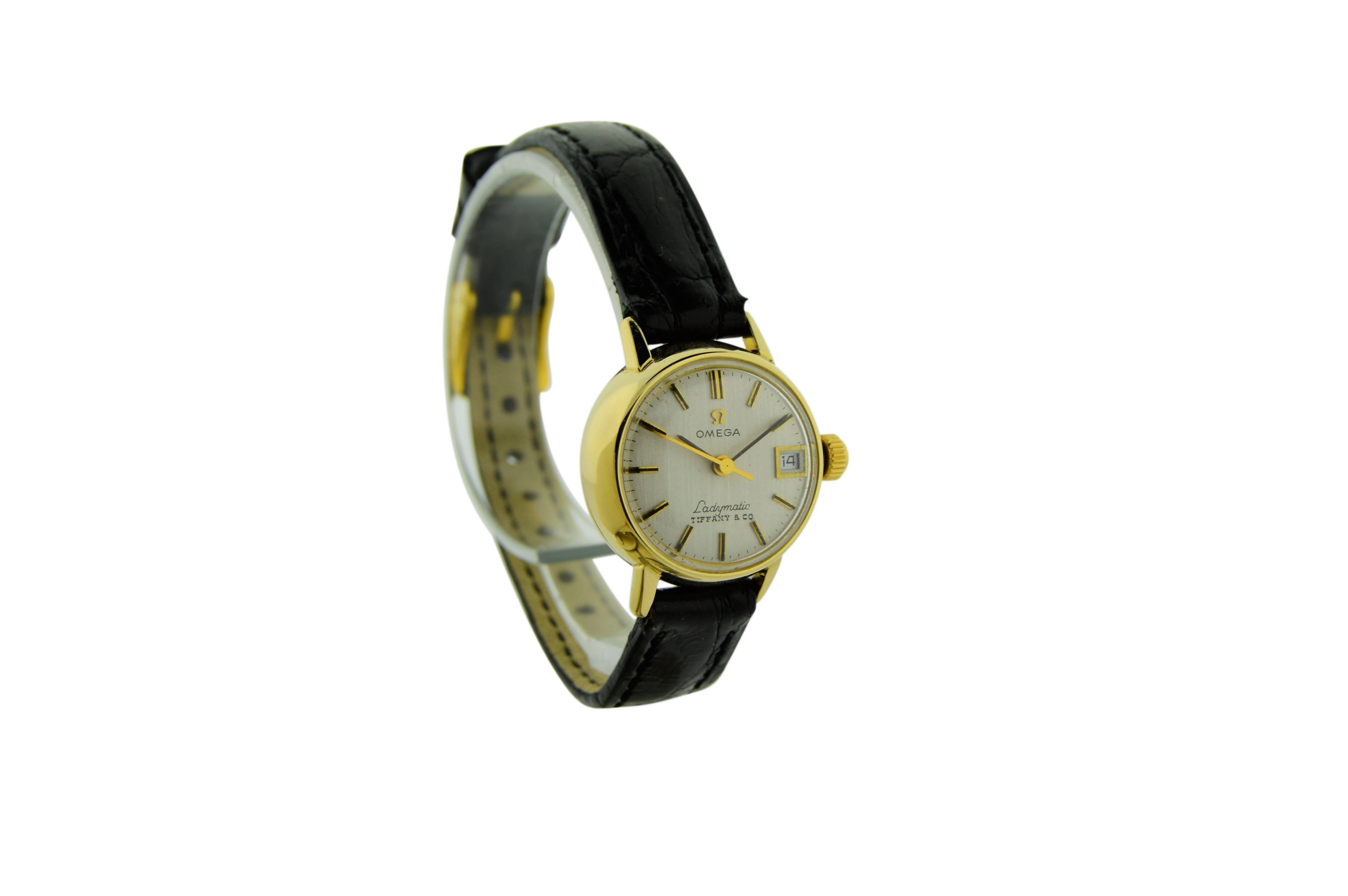 FACTORY / HOUSE: Omega Watch Company
STYLE / REFERENCE: Automatic / Date / Strap 
METAL / MATERIAL: 18Kt. Yellow Gold
DIMENSIONS: 25mm X 21mm
CIRCA: 1960's
MOVEMENT / CALIBER: Automatic / 17 Jewels 
DIAL / HANDS: Original Silvered Linen with Baton