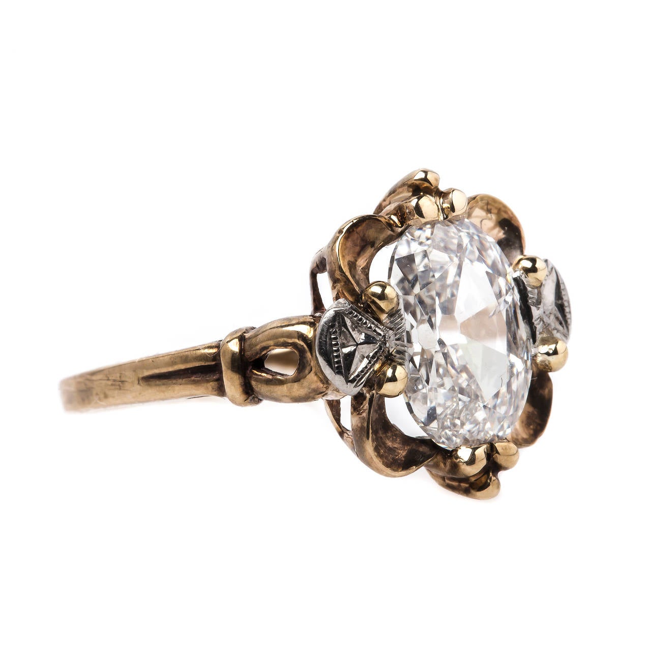 Carmel is a spectacular authentic Retro era (circa 1940) 10k yellow and white gold ring centering an unusual 1.69ct EGL certified Oval Modified Brilliant cut diamond graded H color and SI2 clarity. The unique center diamond is enhanced with decadent