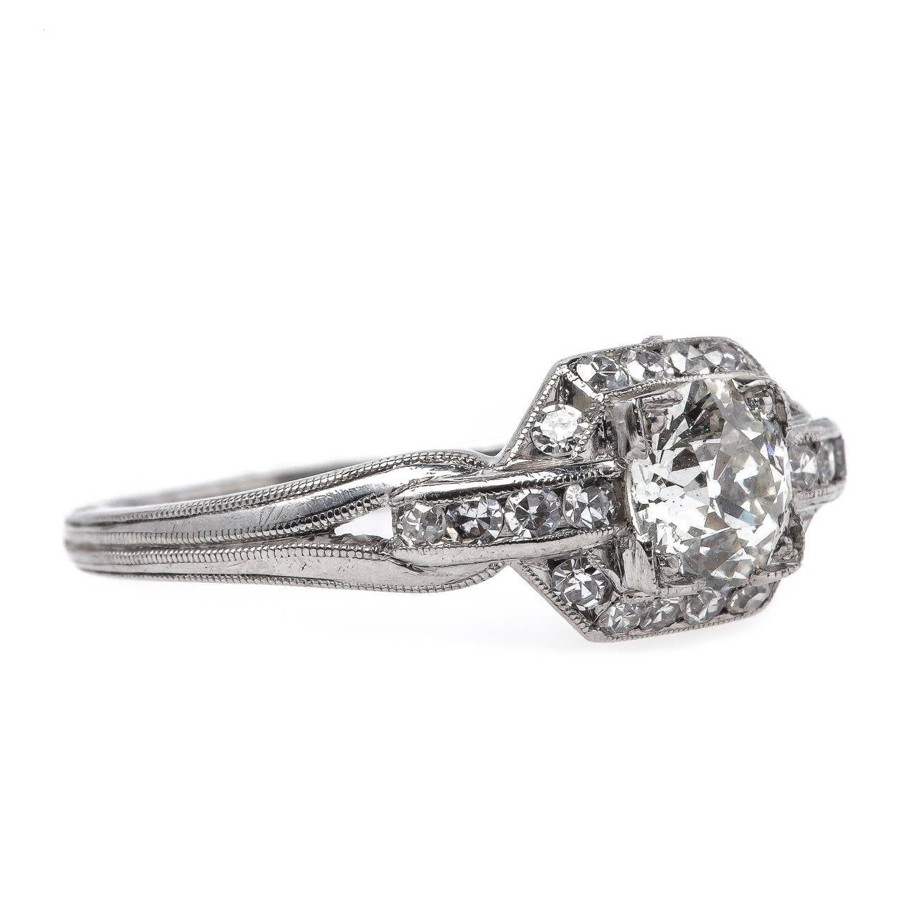 Freeport is a gorgeous and authentic Art Deco era (circa 1920) platinum ring centering a box-set 0.62ct EGL certified Old European Cut diamond graded J color and VS2 clarity. The timeless ring is further framed by a delicate halo of twenty Single