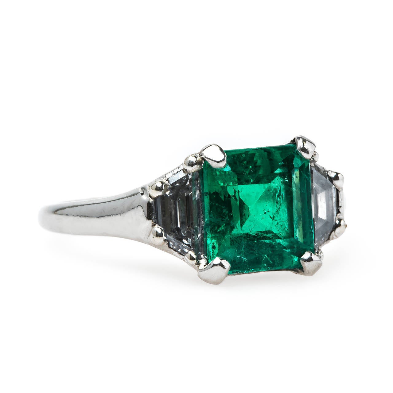St. Charles is a chic, authentic Mid-Century (circa 1950) platinum-set emerald and diamond engagement ring featuring an extraordinary 1.35ct Step-Cut square emerald. This stunning emerald is accompanied by a Guild Laboratory certificate stating that