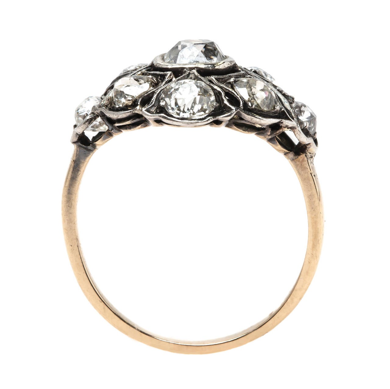 Broken Arrow is an incredible Victorian era (circa 1880) silver topped 14k yellow gold ring. Our gemology team believes it was originally a brooch that was converted into this stunning ring during the 1940's. This impeccable bombe style cluster ring