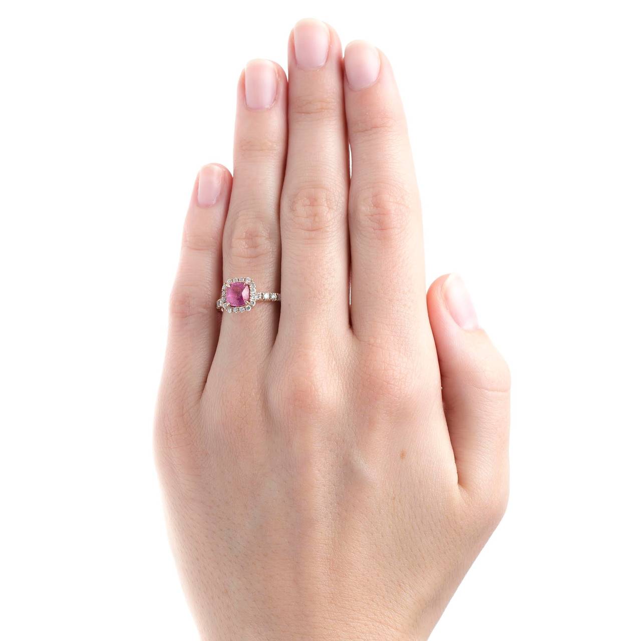 Eureka Springs is a contemporary (circa 2005) halo engagement ring made from 14k rose gold centering a 1.29ct natural cushion shaped pink sapphire. This bubblegum pink sapphire is perfectly nestled within a halo of twenty-eight bright white micro