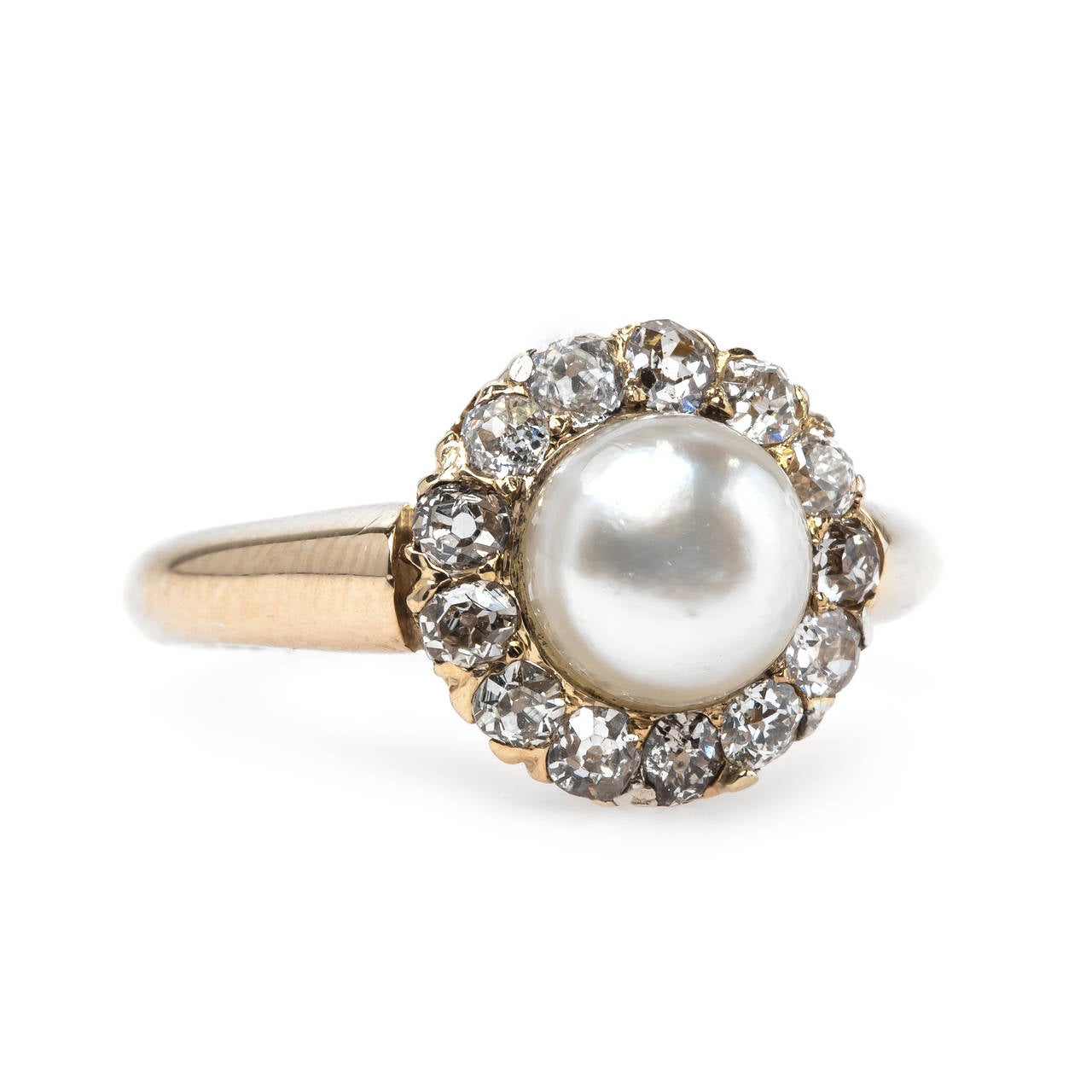Darley is an alluring authentic Victorian Era (circa 1885) 14k yellow gold halo style ring. The center button shaped pearl is 6.9mm in diameter, slightly cream in color and complete with a beautiful luster. Our gemology team believes the pearl is