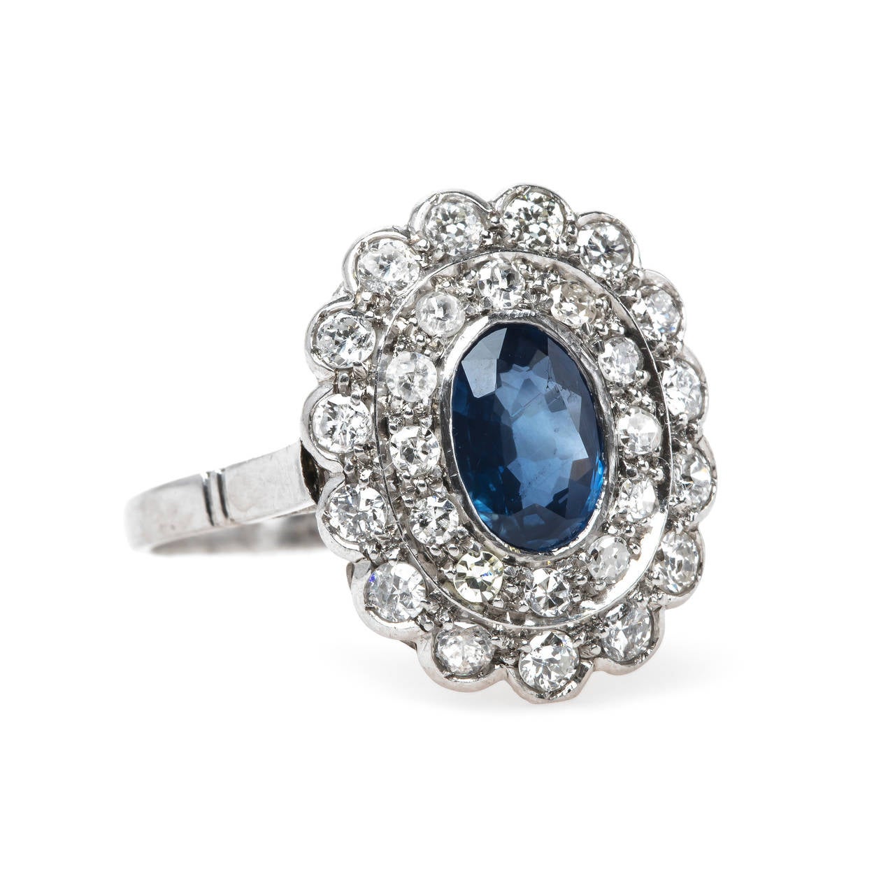 Kenosha is a fabulous authentic Late Art Deco (circa 1935) platinum ring centering a bezel-set natural oval sapphire gauged at 1.15cts accompanied by a Guild Laboratories certificate stating the sapphire is heated with Ceylon Origin. This