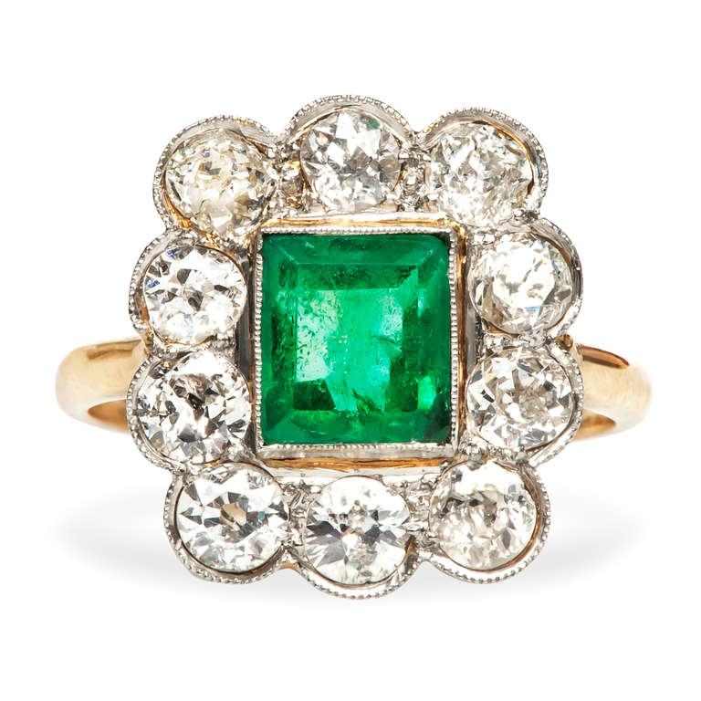 Montrose is a playful Victorian era ring made from 18k yellow gold and topped in platinum. Montrose features a charming Rectangular Step Cut emerald with an approximate weight of 1.20cts, surrounded by a halo of ten Old European Cut diamonds