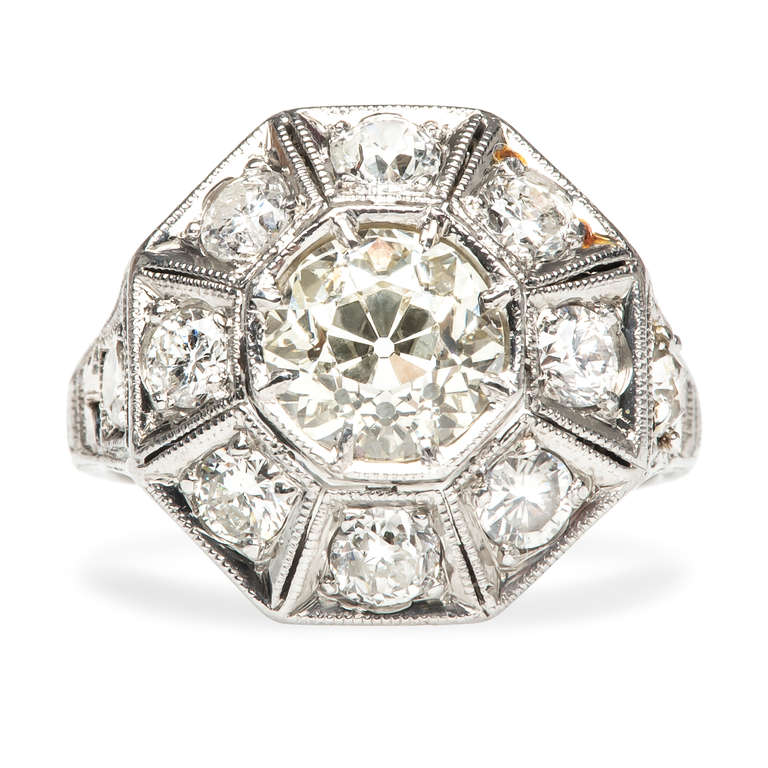Fairfax is an incredible geometric style Art Deco era engagement ring made from platinum, showcasing a 1.12cts EGL certified Old European Cut main diamond, graded M color and VS1 clarity. Fairfax also features ten additional Old European Cut