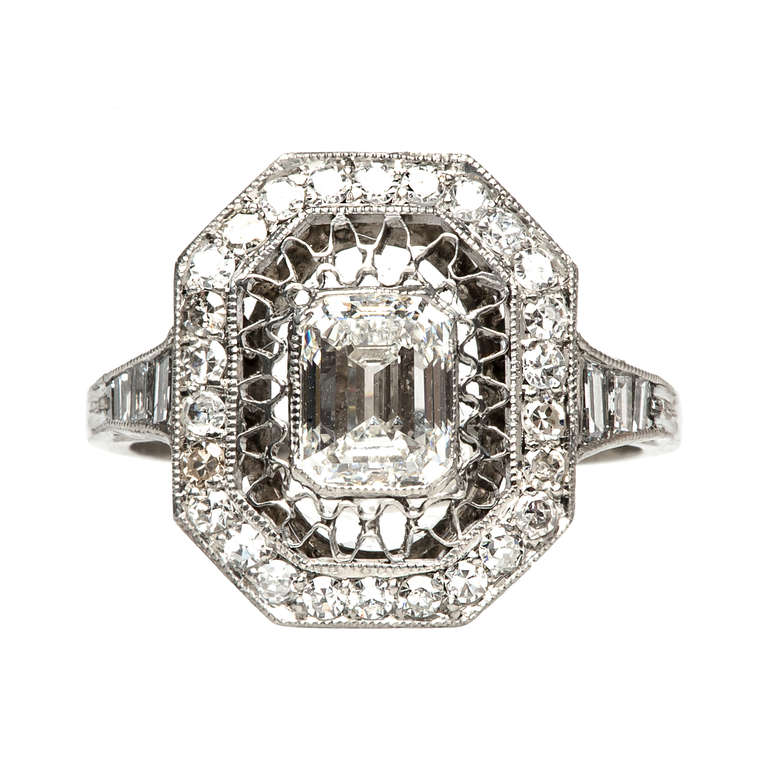 Wimbledon is a beautiful Trumpet & Horn exclusive handmade vintage-inspired engagement ring set in platinum, featuring a bezel set 1.04cts GIA certified Emerald Cut diamond graded H color, and VVS1 clarity. This lovely ring is decorated with ornate