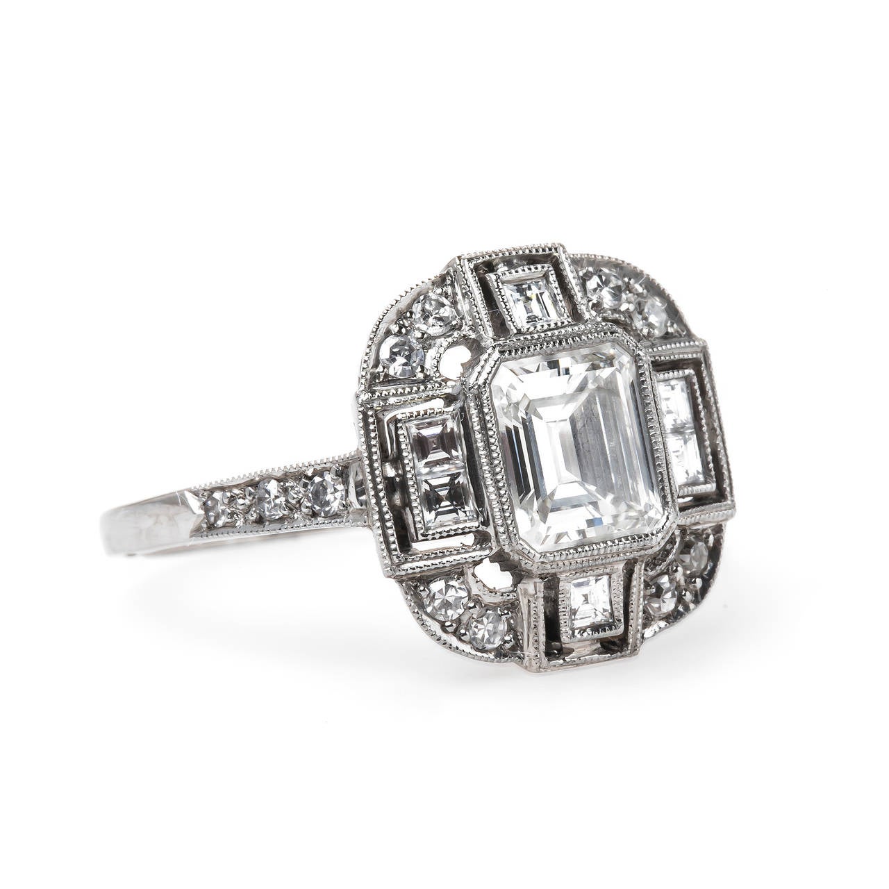 Hampstead Heath is an incredible Trumpet & Horn original design platinum engagement ring centering a high quality bezel set 1.01ct GIA certified Emerald Cut diamond graded G color and VVS2 clarity. Six square Step Cut diamonds frame each side of the