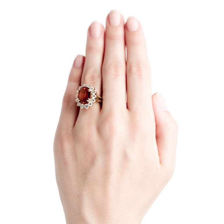 Squaw Valley is a fabulous modern 18k yellow gold cocktail ring centering an intensely orange Spessarite Garnet gauged at approximately 6.00cts accompanied with a Guild Laboraty certificate stating the garnet is of natural color with no clarity