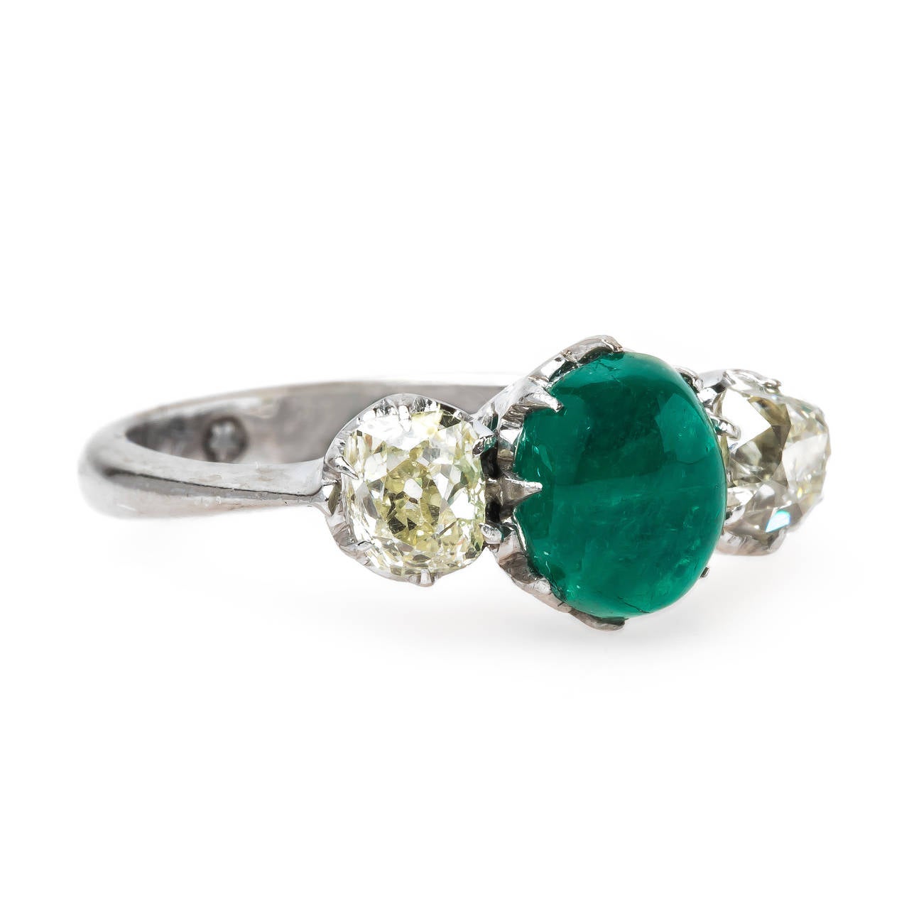 Sunswept is an unusual and authentic Art Deco (circa 1920) 14k white gold ring featuring a unique three-stone combination of stones. A beautifully saturated green natural Cabochon emerald centers the ring, gauged at approximately 1.75cts and
