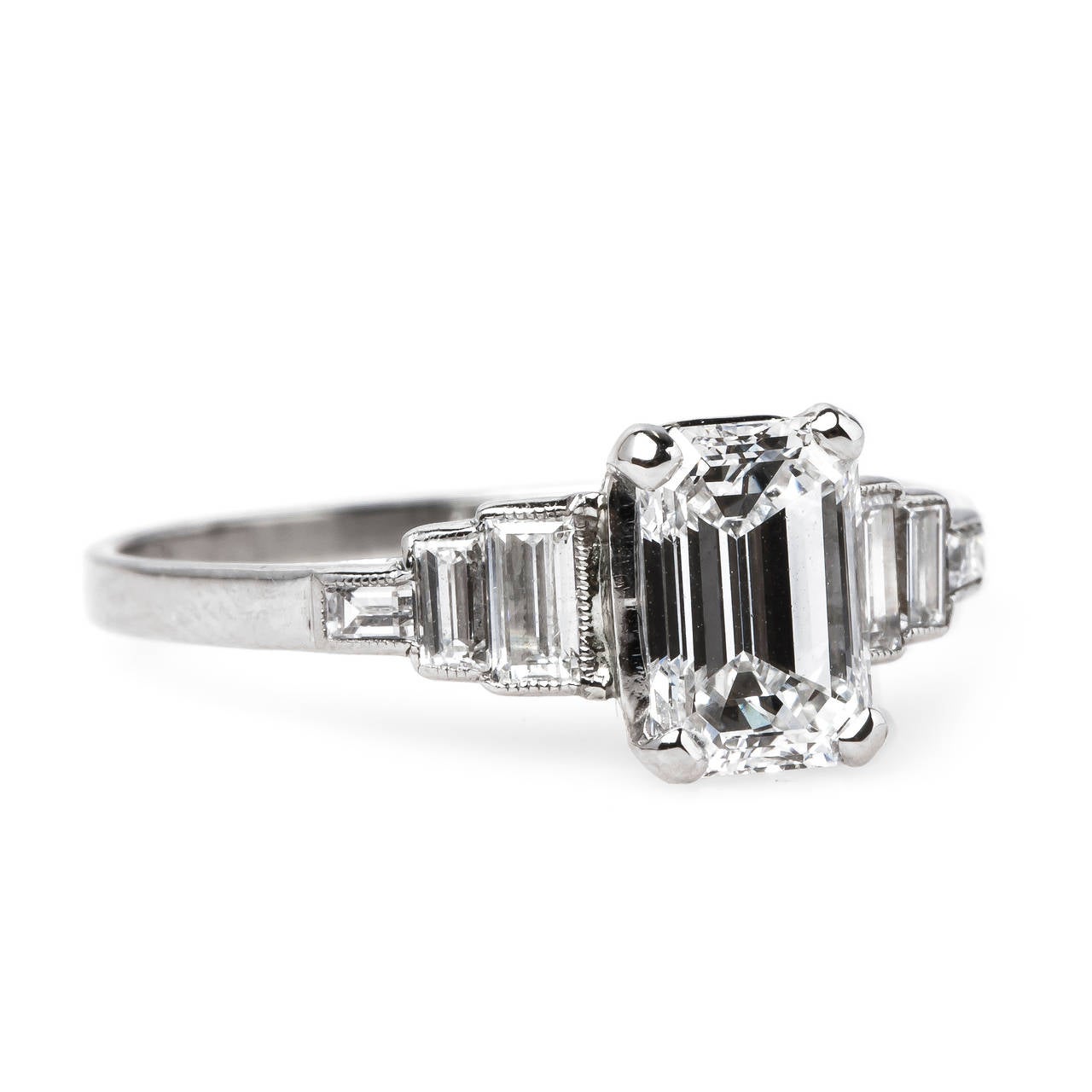 Edendale is a wonderfully classic vintage Art Deco (circa 1925) platinum ring centering a 1.04ct GIA certified Emerald Cut diamond graded F color and VS1 clarity. The center stone is further flanked by six channel set baguette cut diamonds that