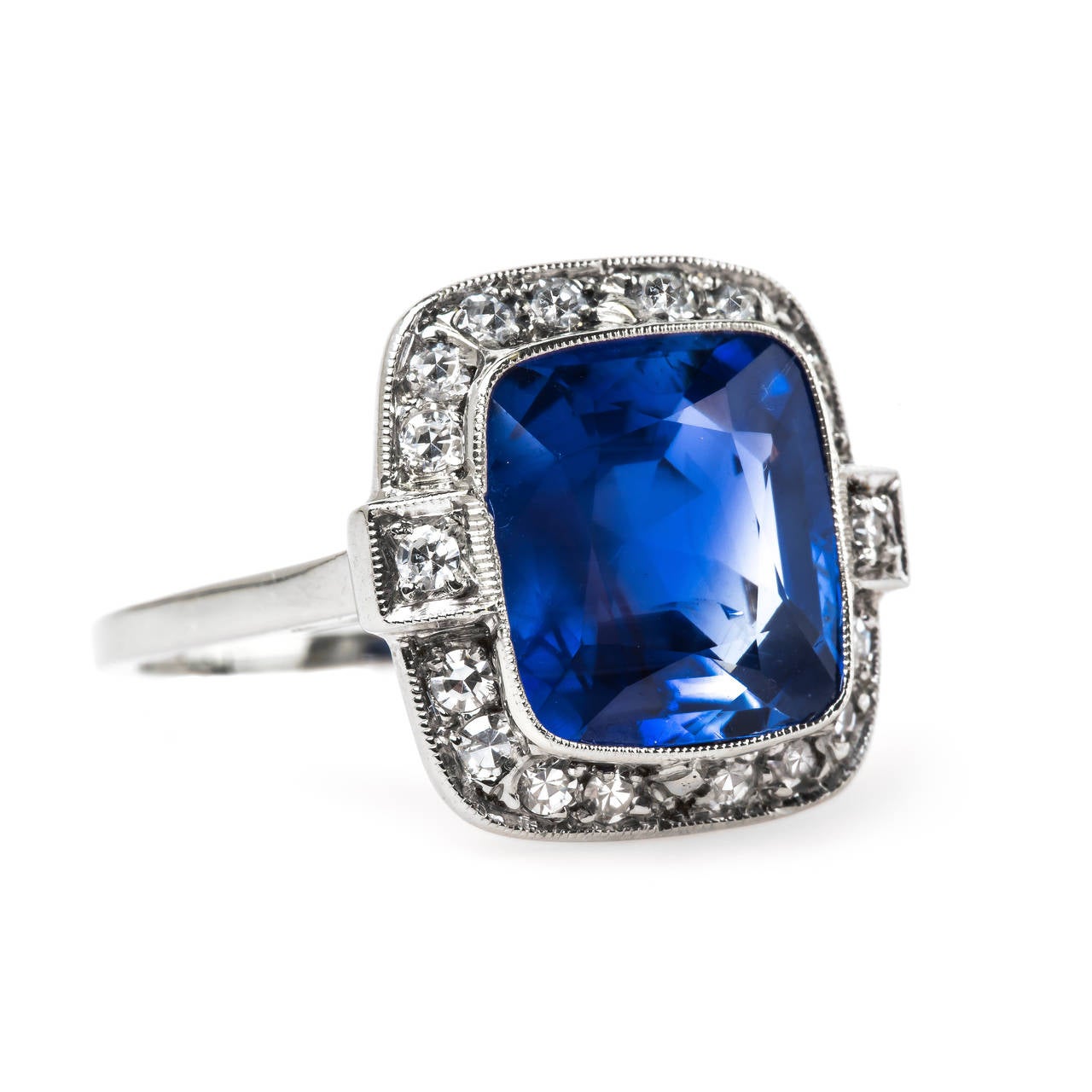 Lausanne is an incredible vintage Late Art Deco (circa 1935) 14k white gold engagement ring. This show-stopping ring centers a bezel set 6.82ct Cushion Cut sapphire accompanied with a GIA certificate stating the sapphire is unheated and from