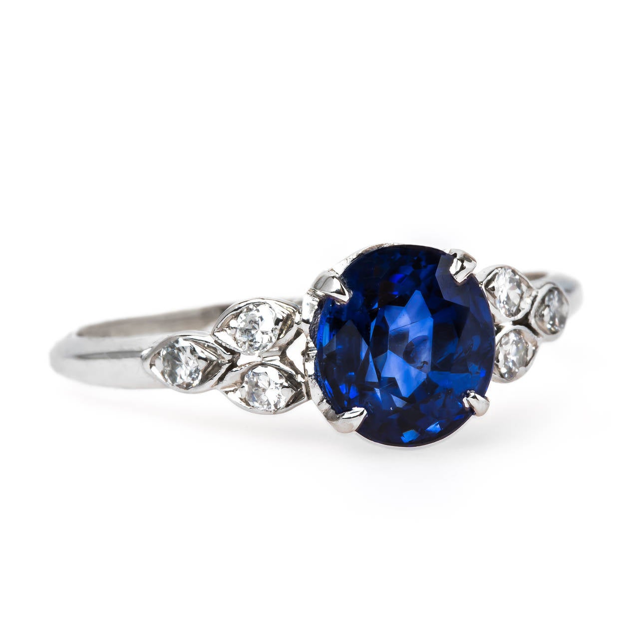 Sea Breeze is a dreamy authentic Mid Century (circa 1950) platinum engagement centering a 2.19ct Oval Sapphire accompanied with a Guild Laboratories certificate stating the sapphire is heated with Ceylon origin. Sea Breeze is further designed with a