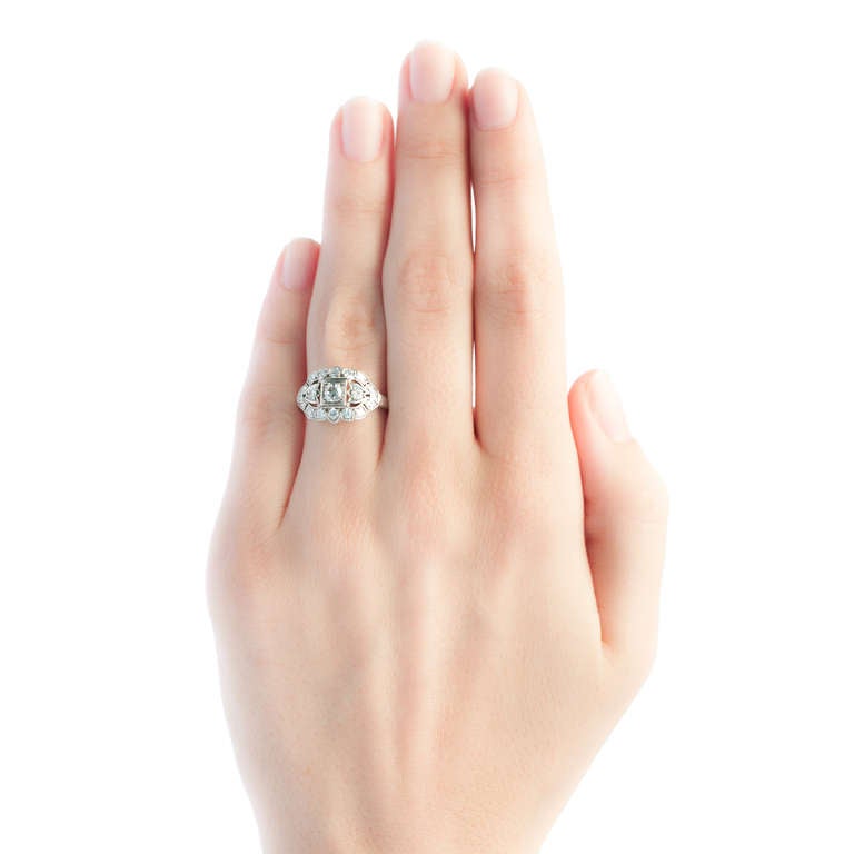 Mobile is a classic Art Deco engagement ring made from platinum centering an Old European cut diamond gauged at 0.18ct graded G-H color and VS clarity. The center diamond is set in a crisp square setting and beautifully framed by fourteen old full
