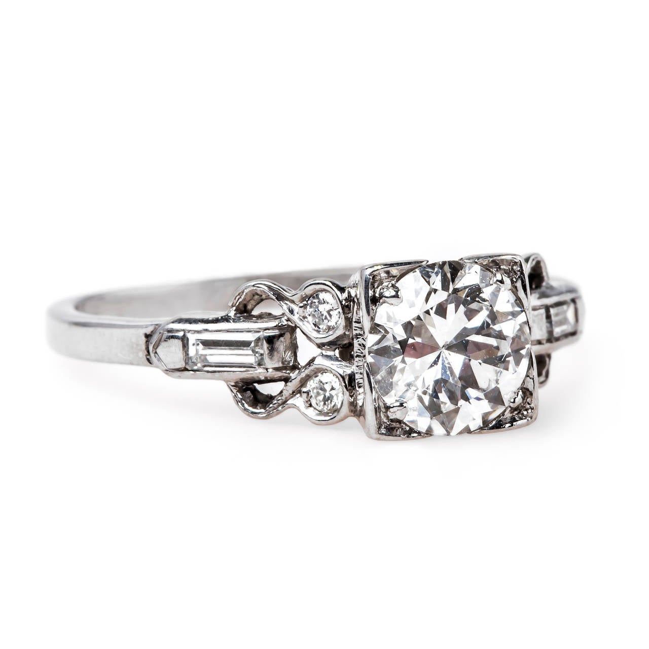 Bridgewater is a tailored Art Deco (circa 1930) platinum ring centering a box-set EGL certified 0.84ct Round Brilliant Cut diamond graded E color and SI1 clarity. This incredibly white diamond is enhanced with unique detailing of four bezel set
