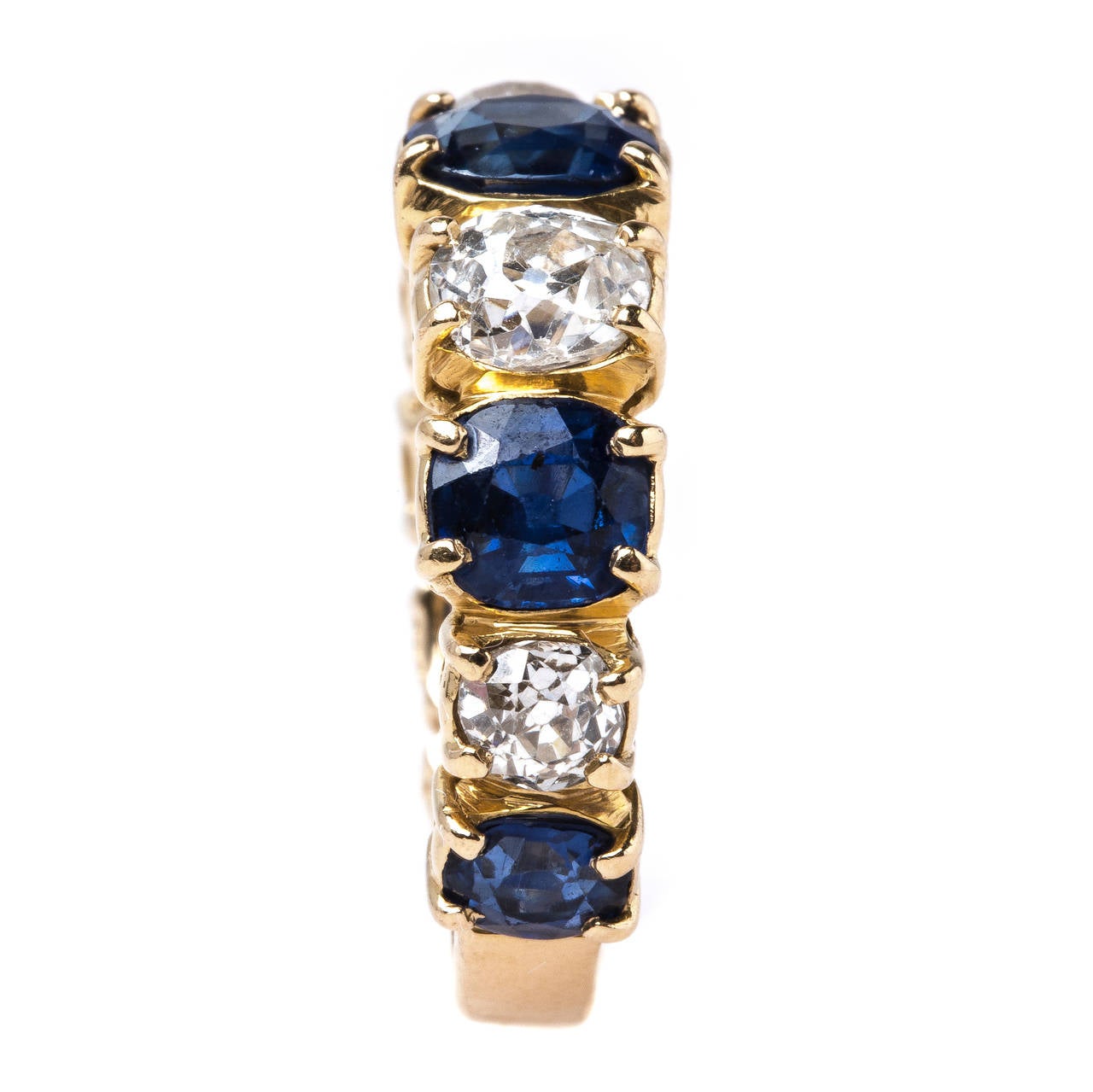 Bridlington is an amazing one-of-a-kind Victorian era (circa 1900) 18k yellow gold sapphire and diamond band. The ring features five prong set Cushion Cut natural sapphires totaling approximately 2.30ct accompanied by a Guild Laboratories