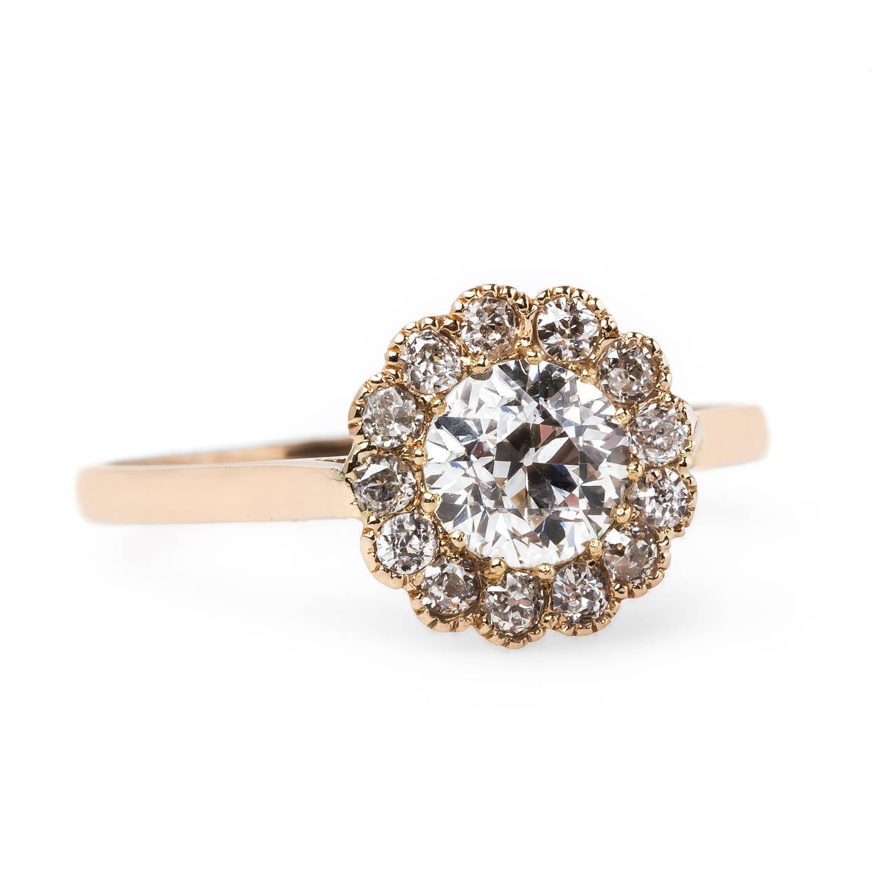 Sunset Hill is a fantastic Edwardian era (circa 1915) 14k rose gold ring centering a scintillating 0.64ct EGL certified Old European Cut diamond graded E color and SI1 clarity. The ring is further designed with thirteen Old European Cut diamonds