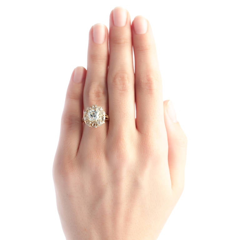 Cedar Hill is a show stopping Victorian era cluster ring made from 18k yellow gold. This elegant ring scintillates from every angle, centering an exquisite 2.04ct EGL certified Old Mine Cushion Cut diamond graded K color and SI1 clarity surrounded