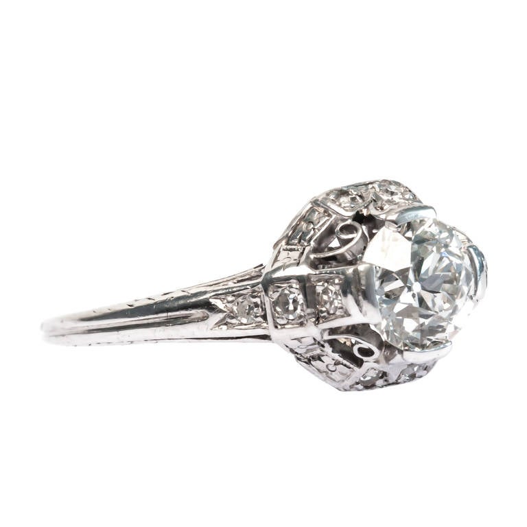 Pomona is a delicate Edwardian era platinum engagement ring centering a sparkling 0.93ct EGL certified Old European Cut diamond graded H color and VS1 clarity. Pomona is framed by twelve Single Cut diamonds totaling approximately 0.10ct., and