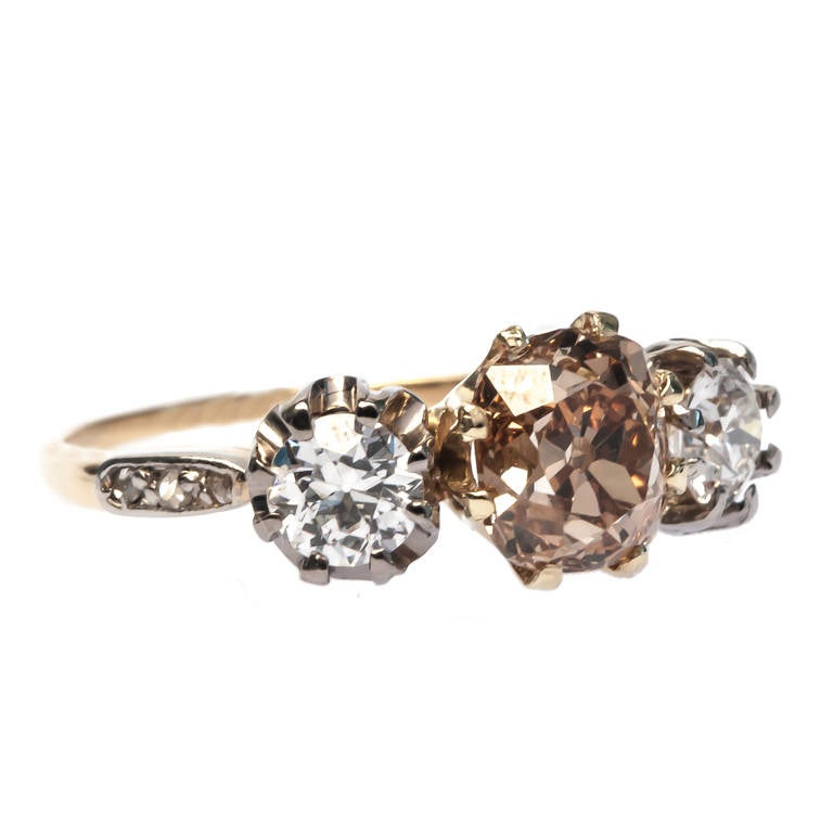 Williamsburg is a one of a kind Victorian platinum and 18k yellow gold three stone ring centering a 1.70ct GIA certified Old Mine Brilliant graded Fancy Brown-Yellow and VS2 clarity. Williamsburg is flanked on either side by two Old European cut
