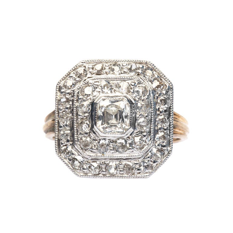 Yosemite is an elegant Edwardian era ring made from platinum topped 14k yellow gold, starring a pretty asscher cut diamond gauged at 0.62c and graded I-J color. This gorgeous bezel set diamond is surrounded by two octagonal diamond halos featuring