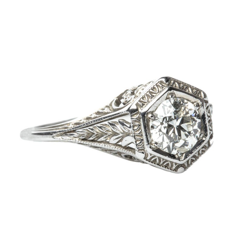 Bristlewood is beautifully detailed Edwardian era engagement ring made from 18k white gold centering a 0.58ct EGL certified Old European Cut diamond  graded H color and SI3 clarity. A raised hexagonal setting envelops the sparkling solitaire diamond