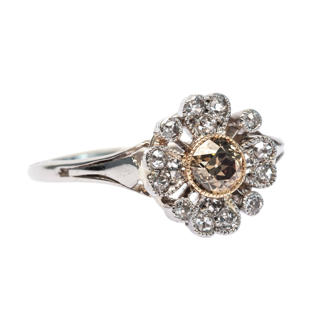 Roxbury is a fabulous Edwardian platinum and 18k yellow gold ring that has been converted from a decadent stick pin. Roxbury centers a fancy yellow brown Old European cut diamond gauged at approximately 0.20ct wrapped within an 18kt yellow gold mil