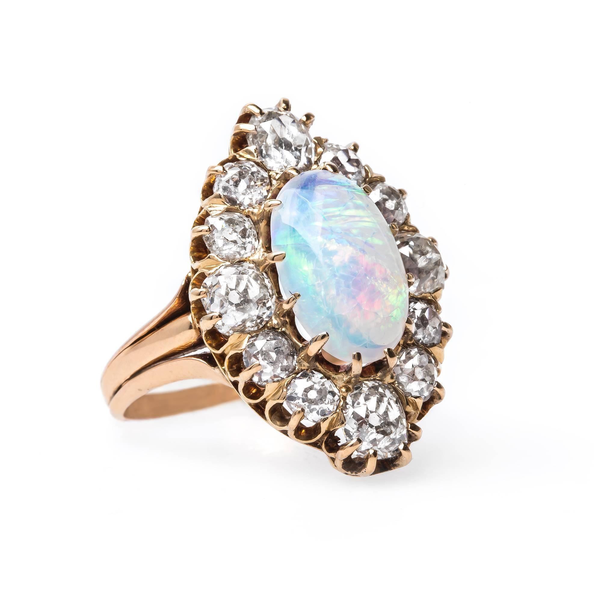 Archcliffe is an incredibly unique and authentic Victorian era (circa 1890) 14k yellow gold and 18k rose gold cocktail ring. This bold vintage right hand ring centers a prong-set Oval Cabochon Australian opal gauged at 11.7mm x 7.5mm and displaying