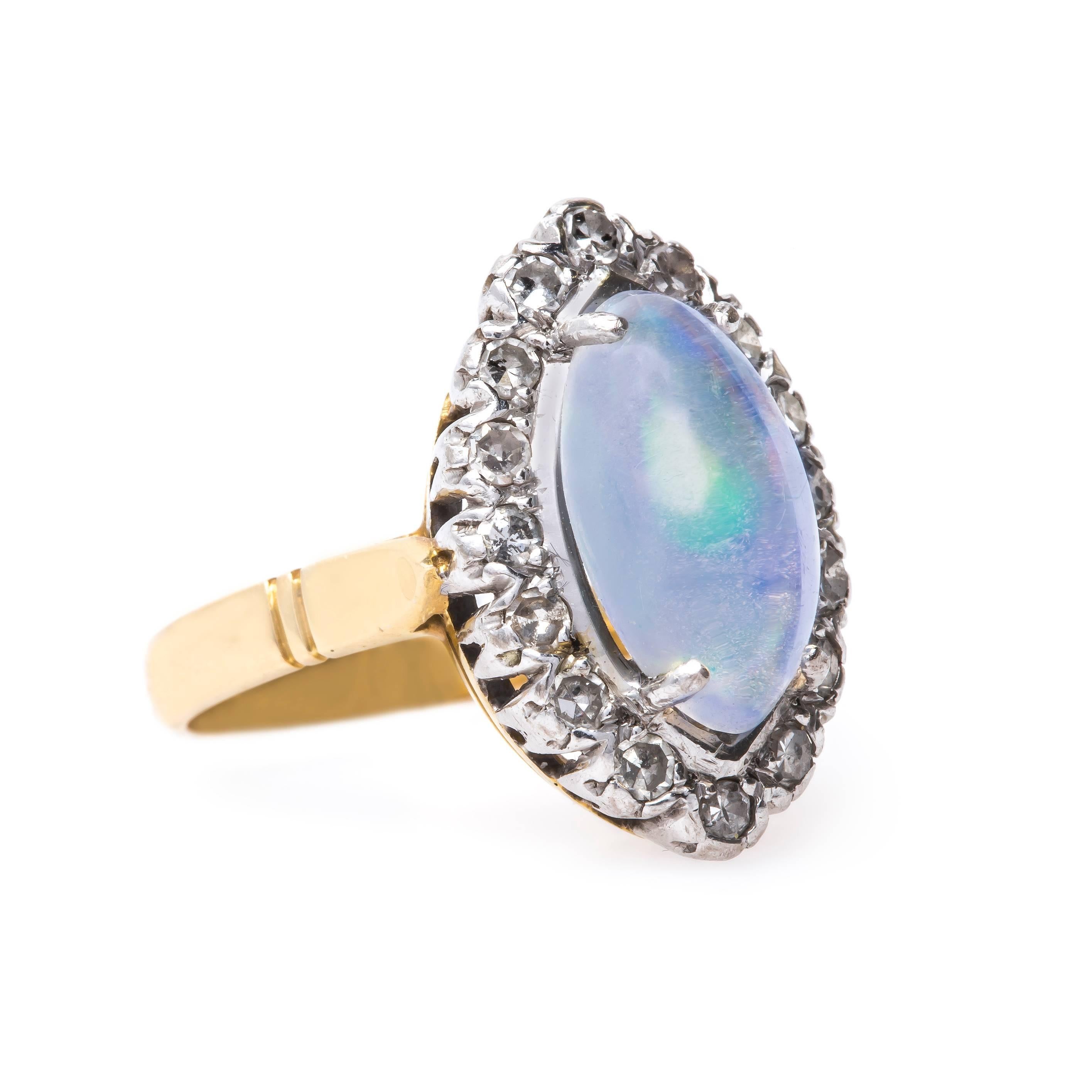 Beechcroft is a bold Retro era (circa 1940) 18k white and yellow gold cocktail ring sure to make a statement! This vintage stunner centers an unusual Contra Luz Marquise Cut Cabochon opal gauged at 13.8mm x 8mm displaying a dreamy transparency mixed