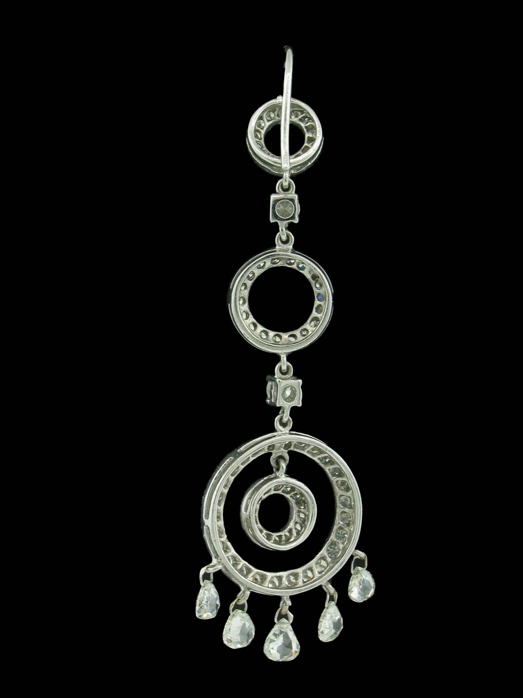 These Diamond earrings consist of 3 open circles graduating smaller to larger from top to bottom.  A smaller concentric circle is suspended inside each of the largest circles, and at the bottom of each of the largest circles are 5 briolette cut