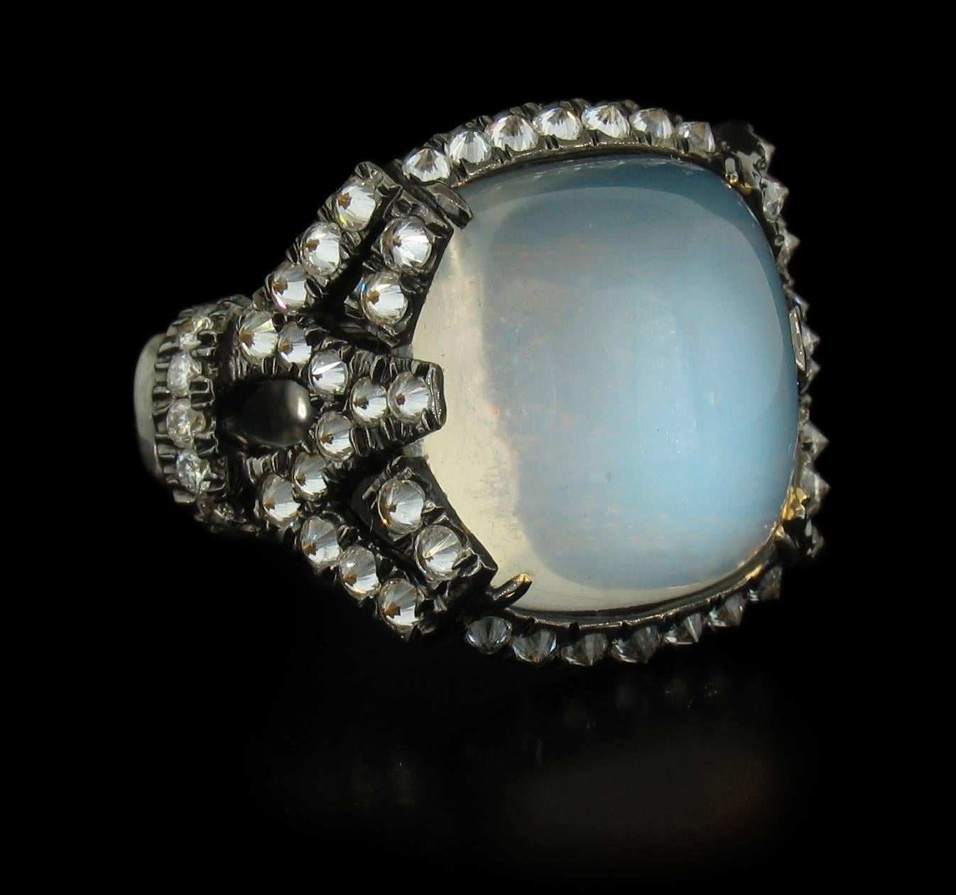 Designed by famed designer Arunashi, This hand made, extraordinary ring features a Silver Moonstone of the highest quality weighing 12.01 carats.  It is surrounded with 64 Diamonds weighing 1.17 carats, approximately F~G-VS2 in color and clarity.