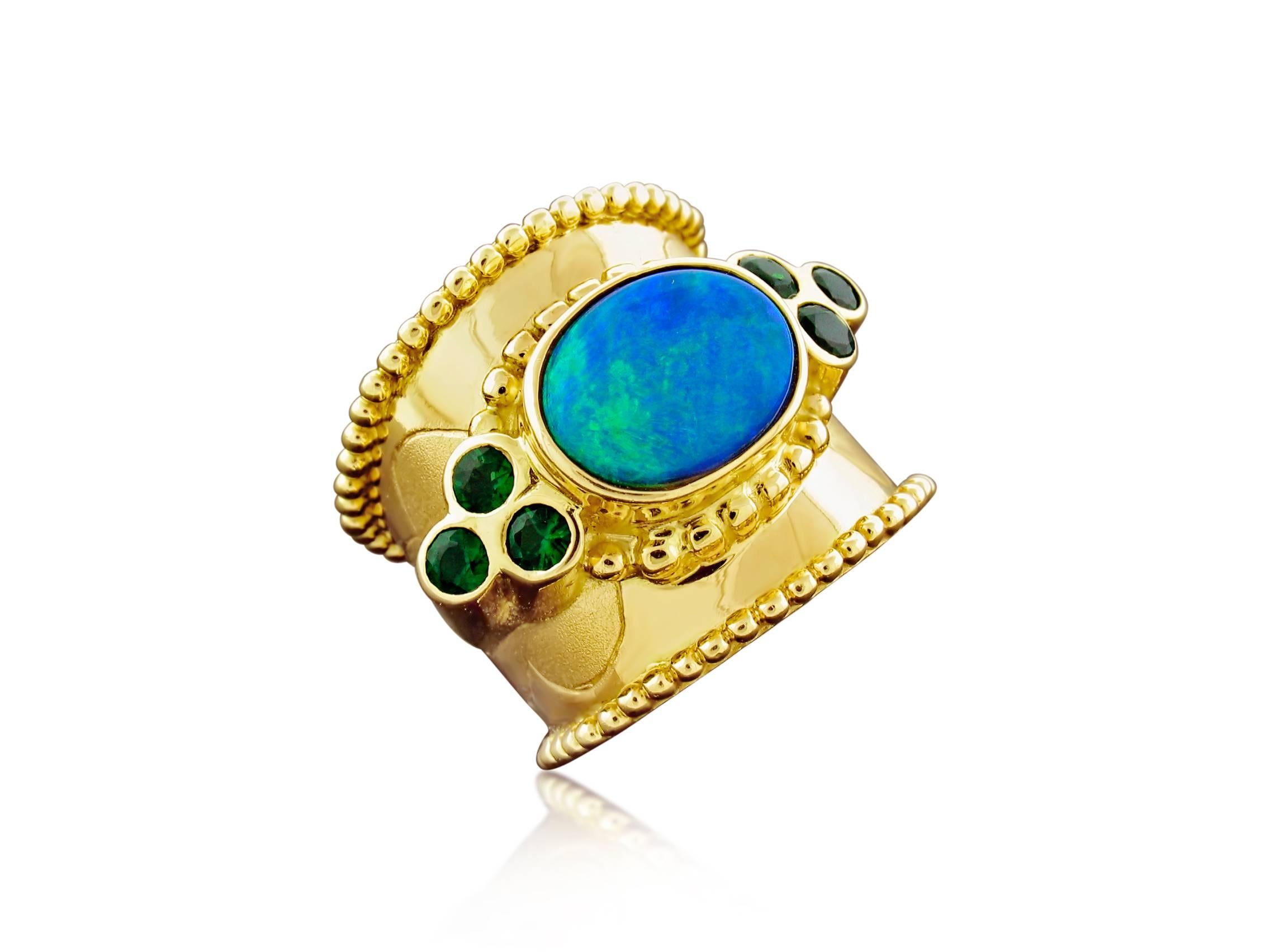 This ring was designed and made by well known designer Paula Crevoshay. It contains an exceptional Blue-Green Black Opal weighing 3.80 carats.  It is accented by  6 Chrome Tourmalines weighing 0.73 carats Size 7 1/2 ~ 8.  Wide band rings tend to fit