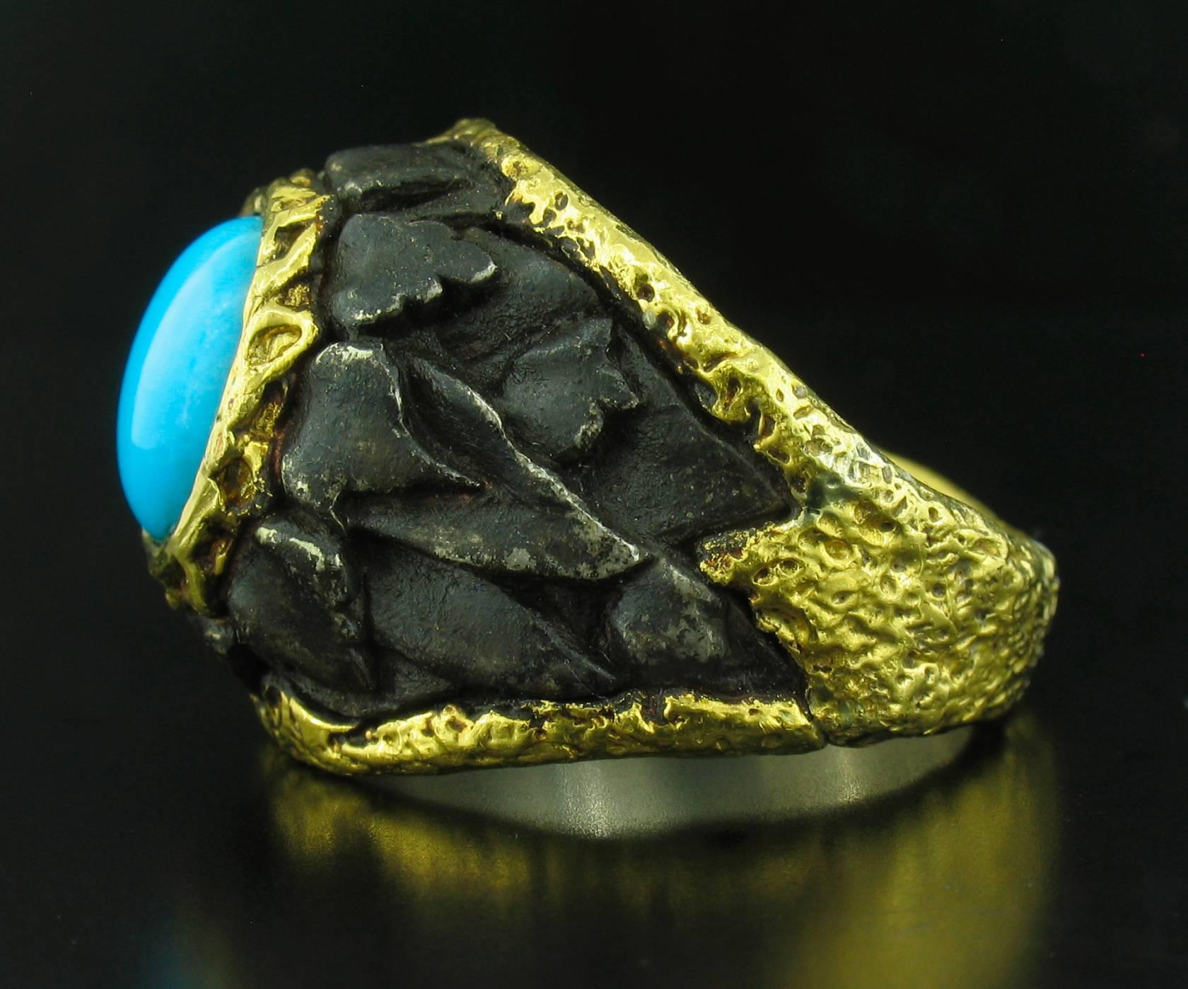 This ring was designed and made by well known designer Victor Velyan. It contains a brilliantly, oval Turquoise cabochon.  It is made of a base of pure Silver with all accent work created in 24k yellow gold The 'brown' is a proprietary patina hand