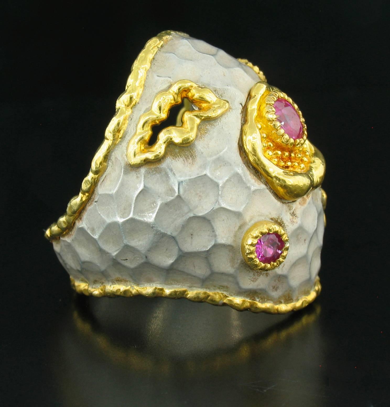 This ring was designed and made by well known designer Victor Velyan. It contains 3 round, faceted Pink Sapphires weighing a total of 0.60 carats.  It is made of a base of pure Silver with all accent work created in 24k yellow gold The 'white' is a
