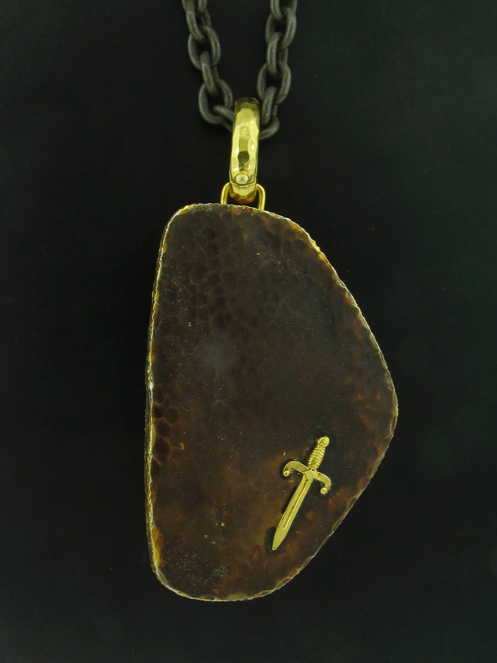 This Ammolite pendant was designed and made by well known designer Victor Velyan.  The Ammolite weighs 84.56 carats.  It is made of a base of pure Silver with all accent work created in 18k yellow gold. The 'brown' on the reverse is a proprietary