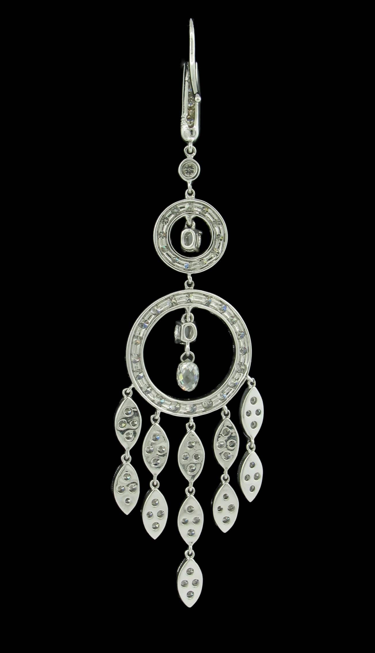 These Diamond earrings feature a chandelier design with two circles, the larger of which is attached with 5 articulated marquis shaped 'streamers' of diamonds.  Suspended inside the larer circle are  briolette cut diamonds.   148 Round Brilliant