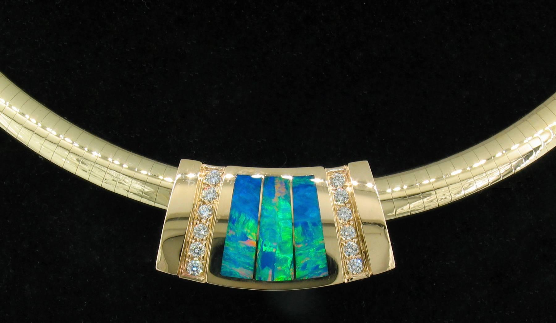 This opal pendant in 14k Yellow gold was made by Mark Hileman It features opal inlay with 12 round brilliant diamonds.  It is signed 'MMH' and measures 5/8"L X 1 1/8"W X 5/16".  It hangs on a 14k yellow gold omega chain stamped '14kt'