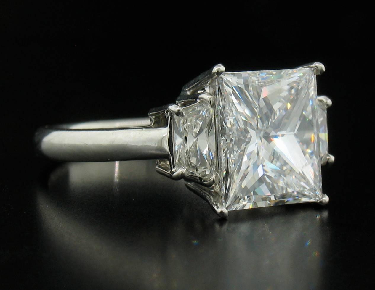 This is a beautiful Diamond Ring with a 4.03ct Princess center stone.  This is an ideal cut stone, hand selected by us.  It is an E - VS2 with a GIA laboratory report.  Two trapazoid Diamonds flank the sides of the center stone and weigh a total of
