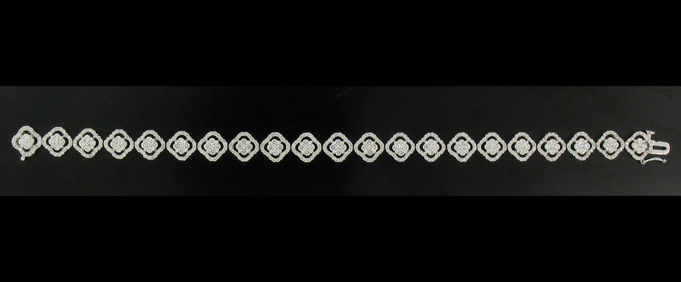 Beautiful 'Quatrefoil' shaped sections make this a lovely diamond tennis bracelet.  Designed by Charles Wolfe, Diamonds weigh a total of 4.12 carats, set in 18k white gold.  Stamped CWC and 18k.  6 3/4"l x 5/16"w x 1/8" deep.