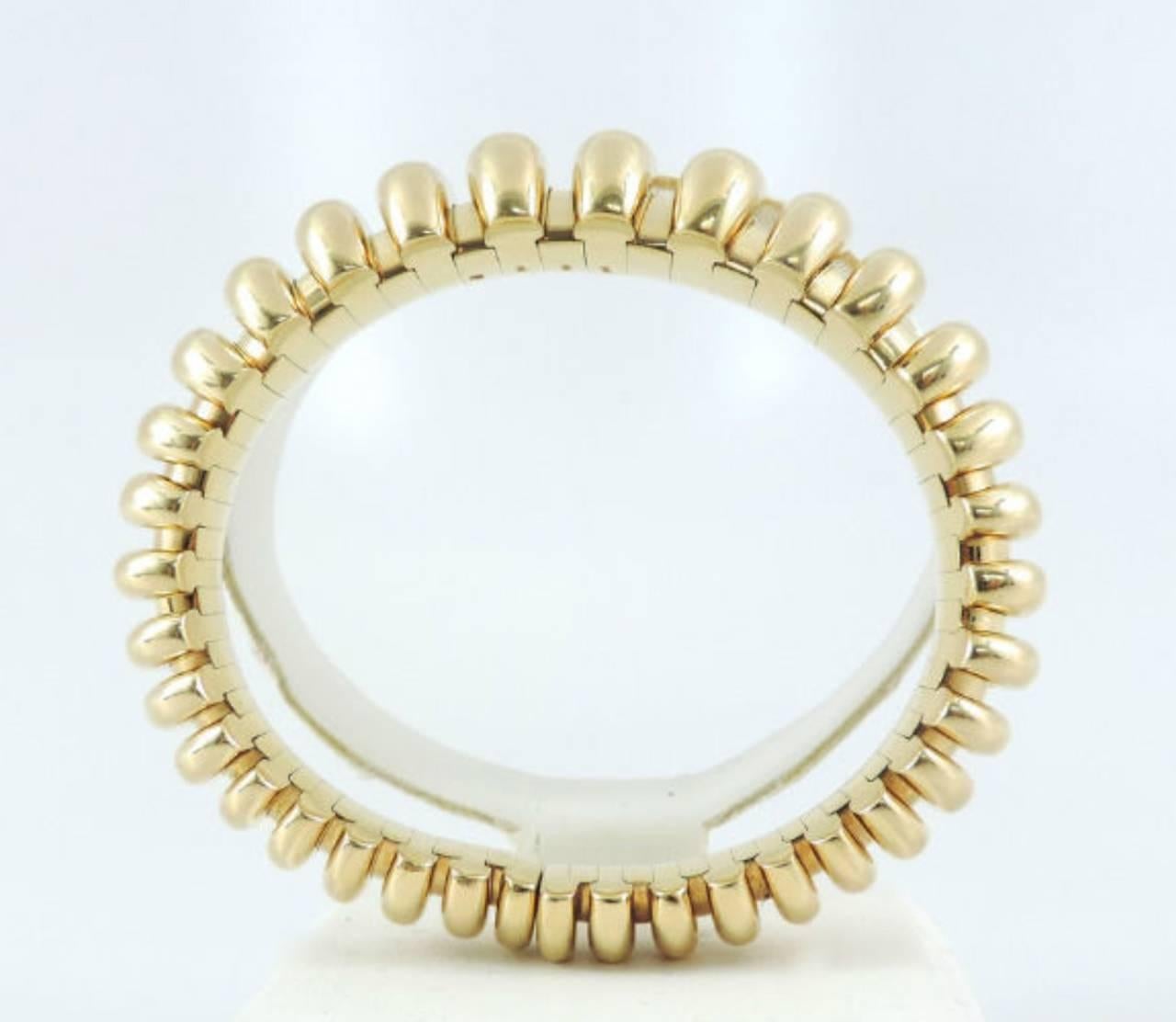 This is an authentic Bvlgari Celtaura 18k, heavy yellow gold flexible cuff bracelet. Fully signed and hallmarked, solid 18k gold, oval bangle that opens to fit 7 inch wrist and smaller. 12mm wide at bottom and 17.50mm at top.  In excellent