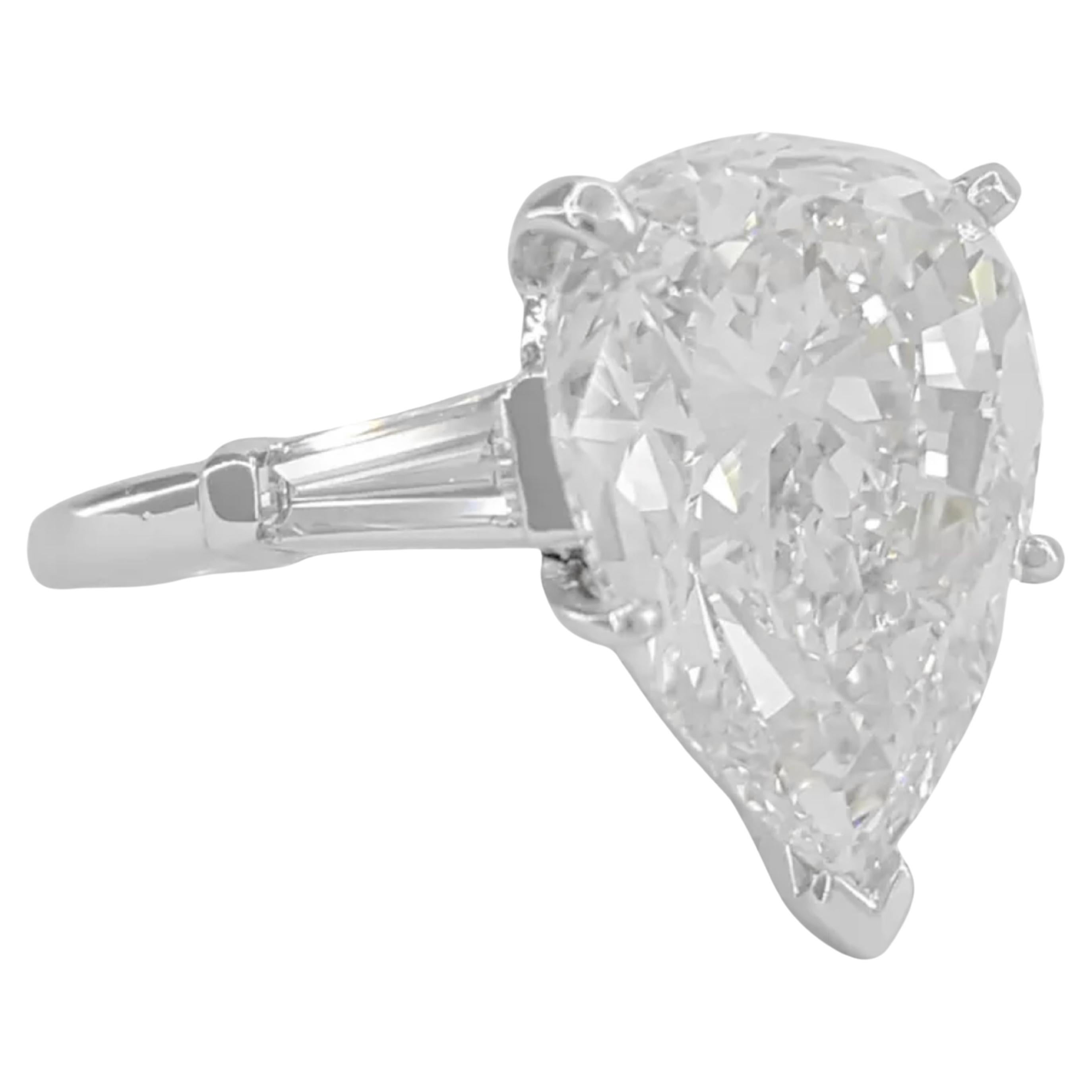 La bague de fiançailles à trois pierres en diamant taille poire d'un poids total de 5 ct est une pièce exquise fabriquée en platine. La pièce maîtresse est un magnifique diamant ovale naturel de 5,23 ct taillé en brillant qui affiche un grade de
