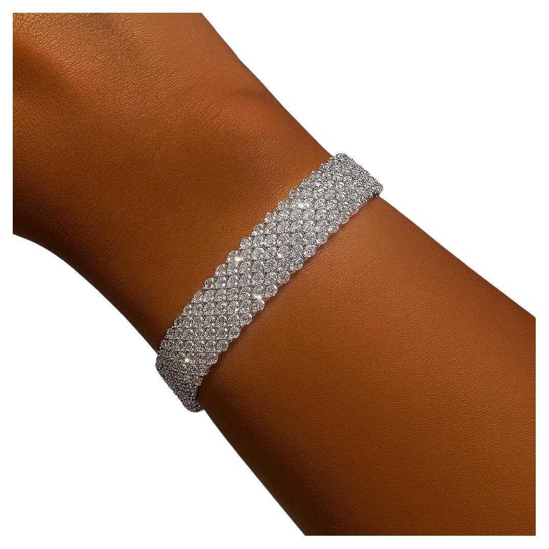 Esta exquisita pulsera ancha de diamantes exhibe siete filas de finos diamantes redondos de talla brillante, meticulosamente engastados en oro blanco macizo de 18 quilates. El diseño ofrece un deslumbrante despliegue de brillo y sofisticación,